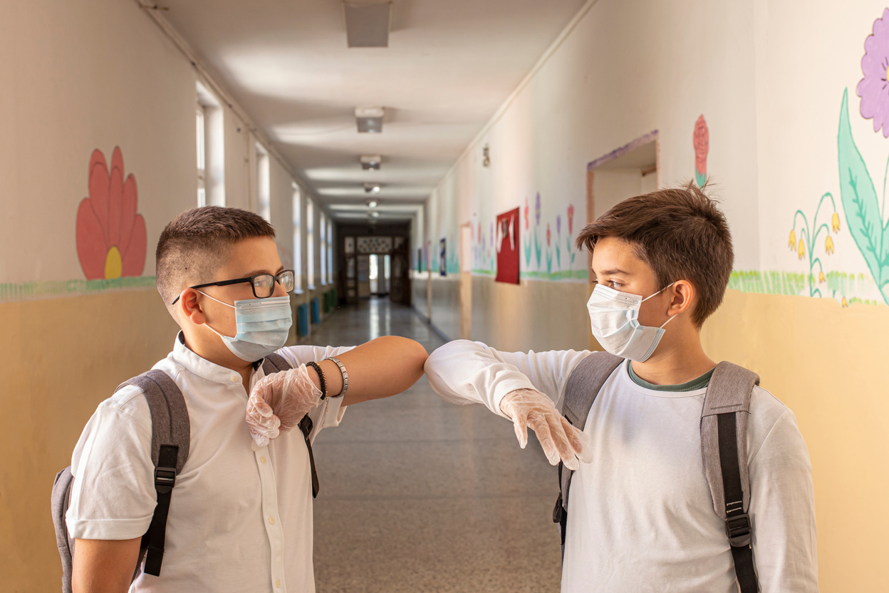 Two boys respecting social distance in school